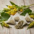 Mullein tea bags surrounded by mullein leaves and yellow flowers on a wooden background